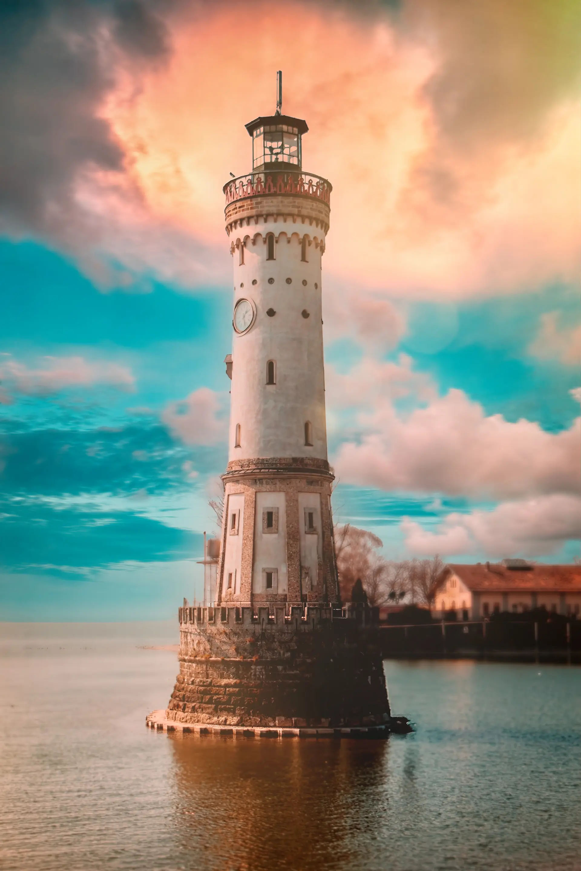Historischer Leuchtturm im Wasser vor dramatischem, farbenfrohem Abendhimmel.